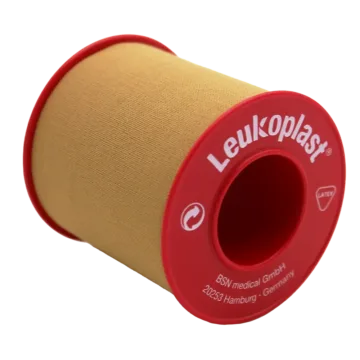 Leukoplast® Standard Rigid tan-coloured zinc oxide tape, 5cm x 5m, offers strong adhesion and high tensile strength, ideal for securing dressings and equipment on intact skin. It's water-repellent, breathable, and features antimicrobial components.